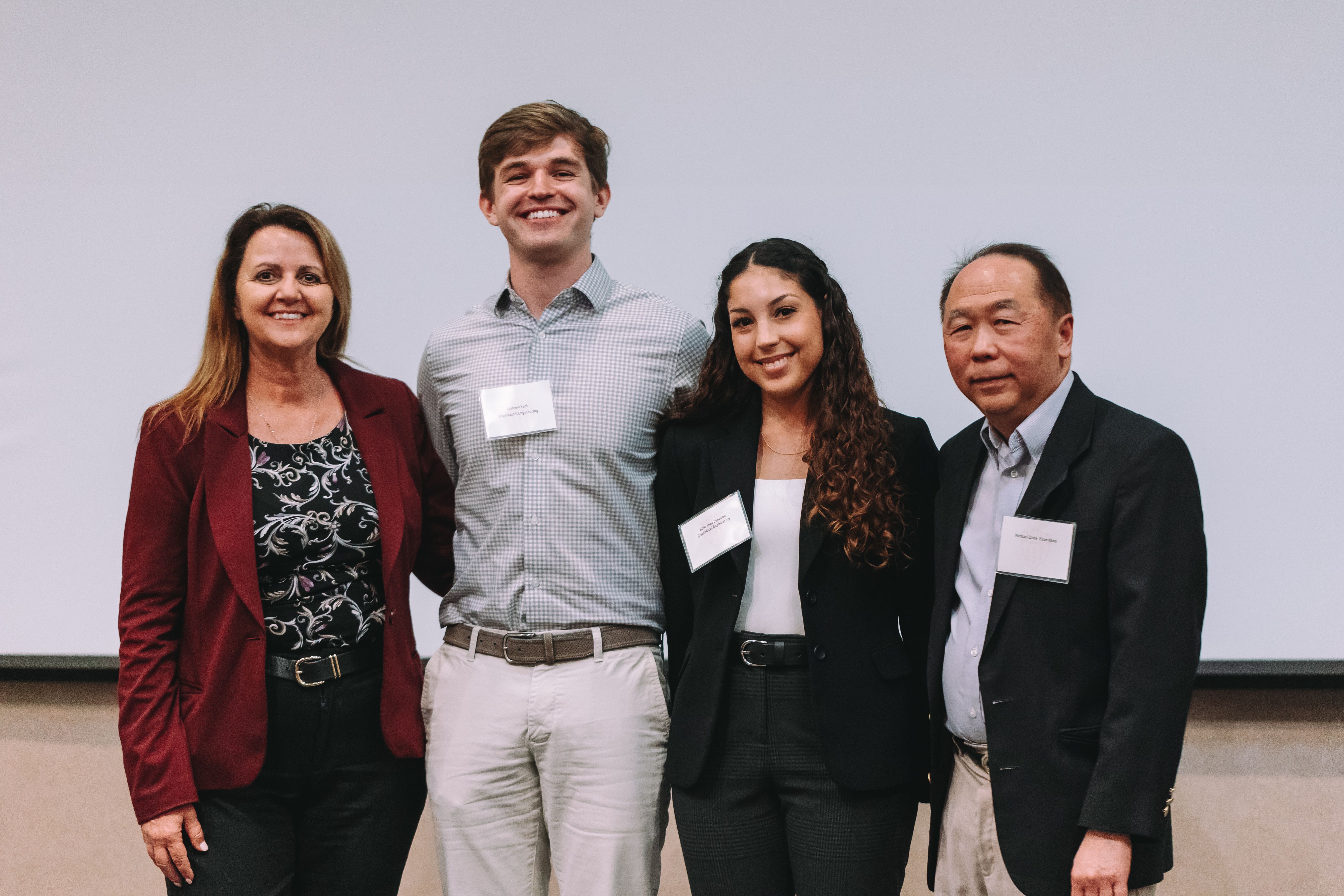 Four people smiling at the camera with their arms around each other. Andrew Yock is second from the left.